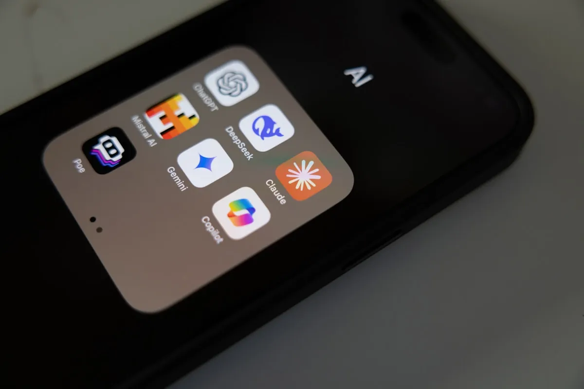 Close-up of a phone screen showing AI apps including ChatGPT, Claude, Gemini, and DeepSeek