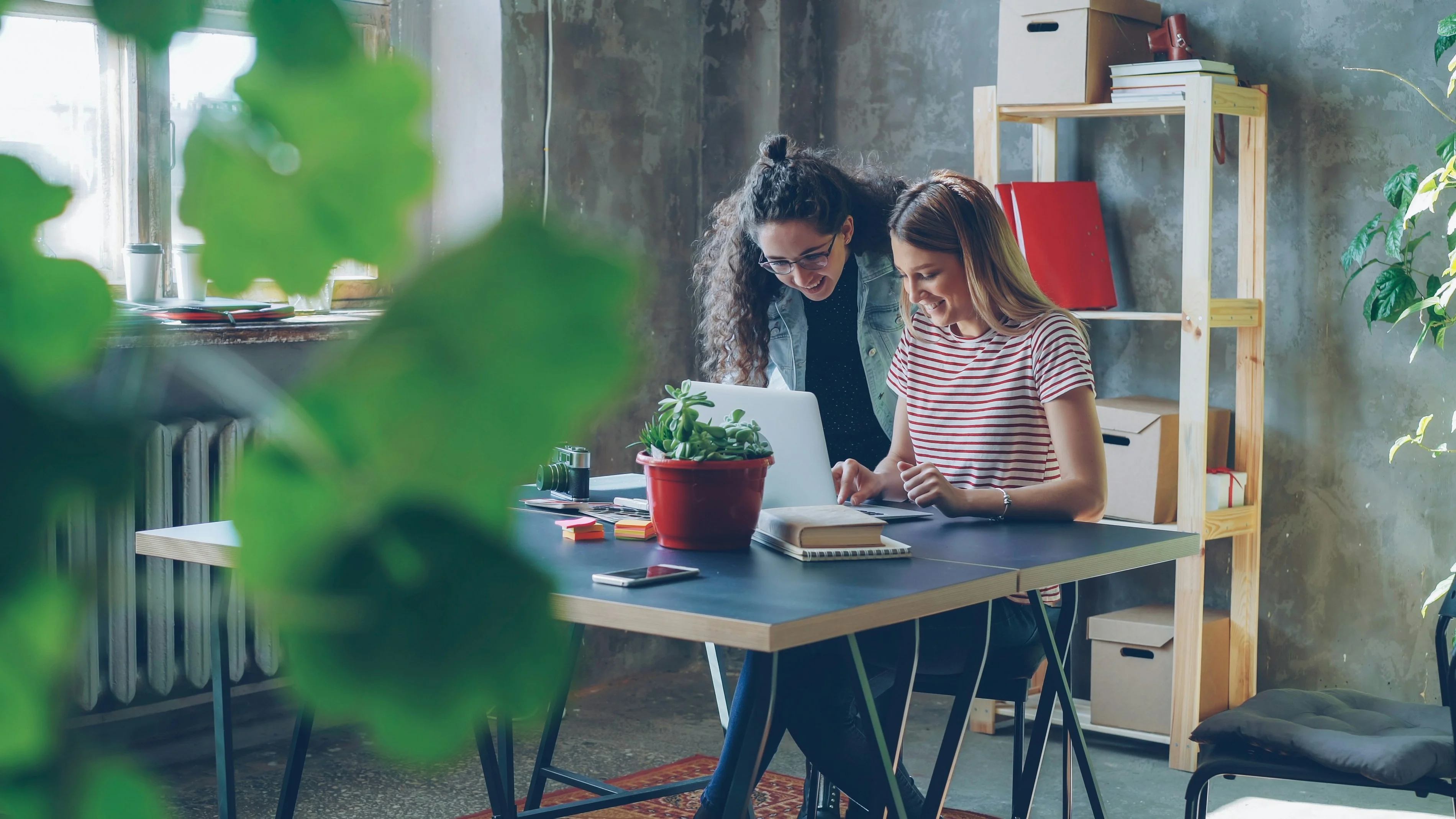 Three colleagues from design, product, and growth gathered around one screen showing the moment a cross-team conversion problem gets connected