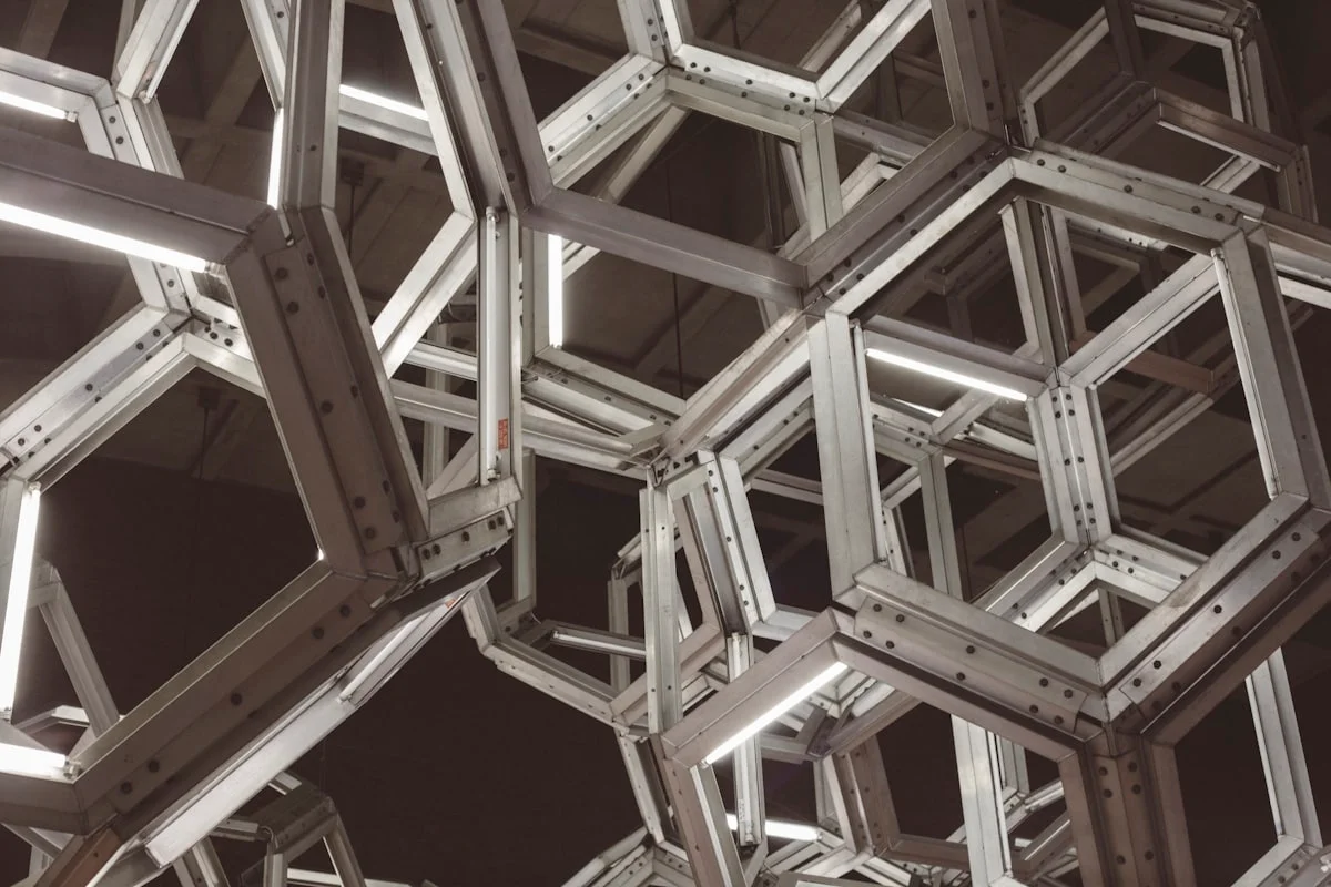 Geometric steel framework structure showing interconnected hexagonal modules, the structural logic beneath what users see